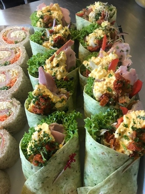 Spinach wraps and pinwheel club sandwiches on a platter