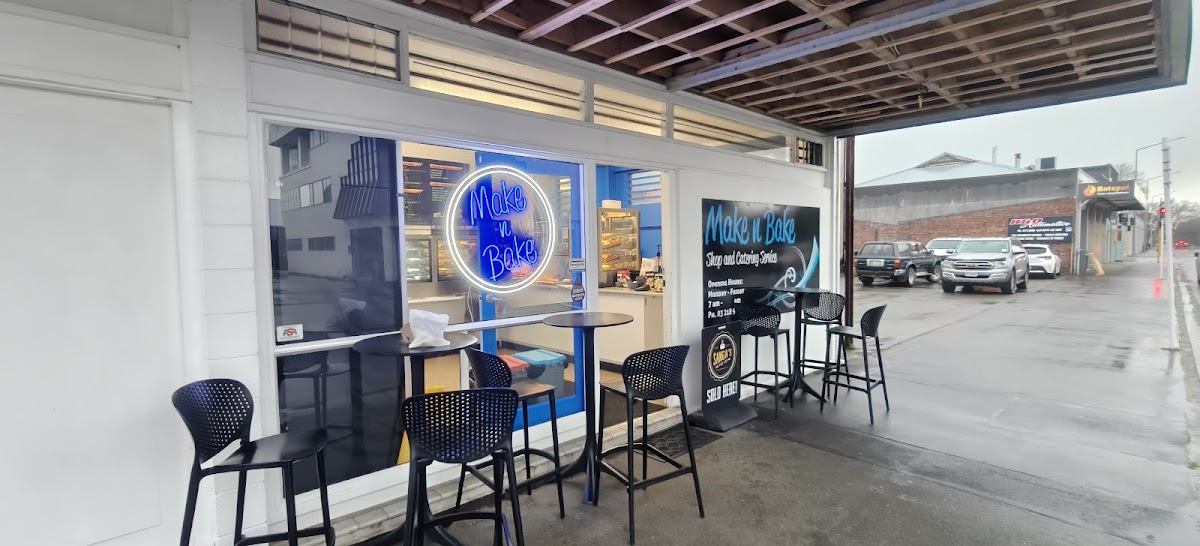 The Make n Bake shopfront with the blue neon sign and street seating
