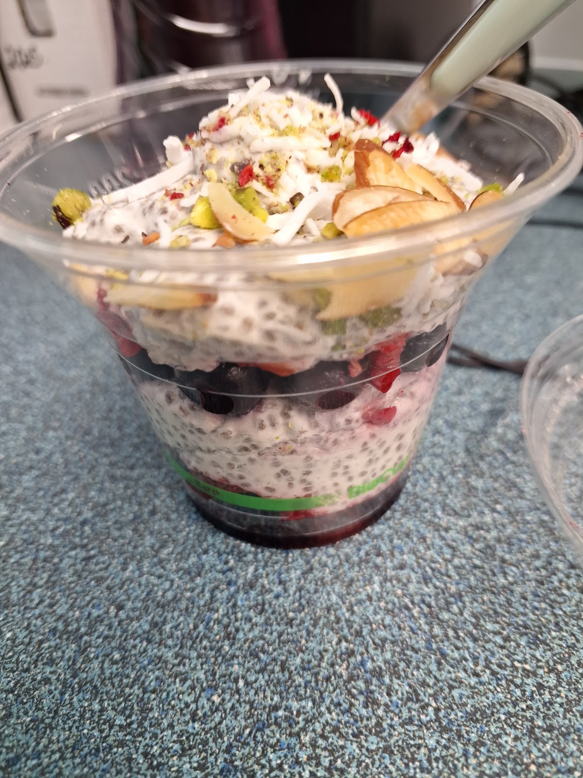 Layered chia pudding cup with berries, coconut and pistachio